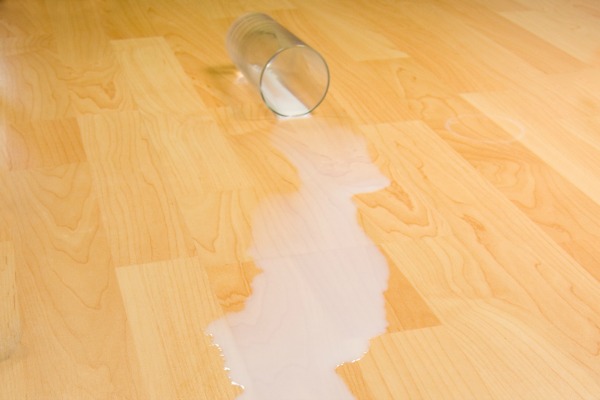 Overturned glass of milk illustrating proverb, do not cry over spilt milk